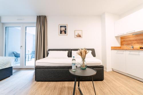 a bedroom with a bed and a table and a kitchen at ZENtrahome - Zentral Outlet Business SmartTV Balkon in Metzingen