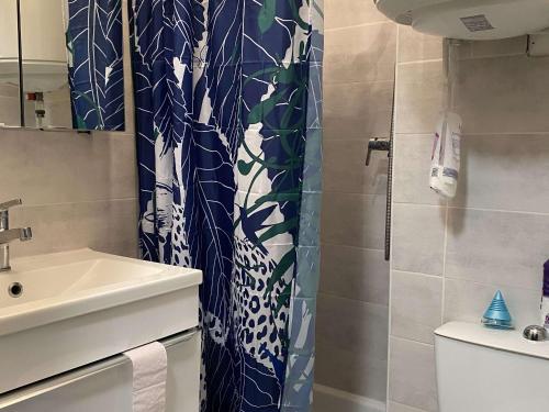 a bathroom with a shower curtain and a sink at Charmant T2 rénové avec clim, WiFi et parking à 15 min des Thermes de Balaruc-les-Bains - FR-1-553-229 in Balaruc-les-Bains