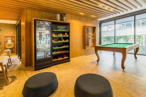 a room with a pool table and a refrigerator at GO 24 by My Way in Porto Alegre