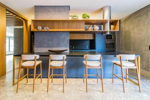 a kitchen with a bar with four stools at GO 24 by My Way in Porto Alegre