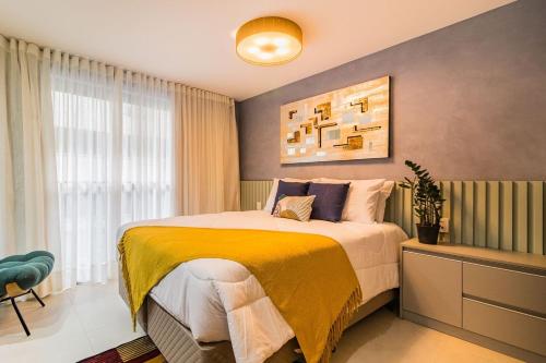 een slaapkamer met een bed met een gele deken bij GO 24 by My Way in Porto Alegre
