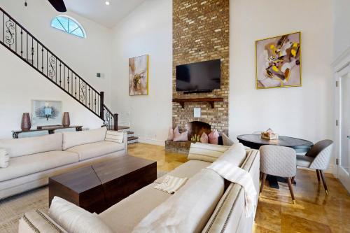 Il comprend un salon doté d'un mobilier blanc et d'une cheminée en briques. dans l'établissement Casa Arboleda, à Leisure World