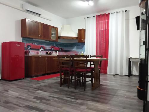 a kitchen with a table and a red refrigerator at Il Cavallino, sul lago Ceresio in Brusimpiano