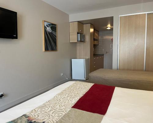 een kleine kamer met een bed en een koelkast bij 460 LOFT Apartments in Bariloche