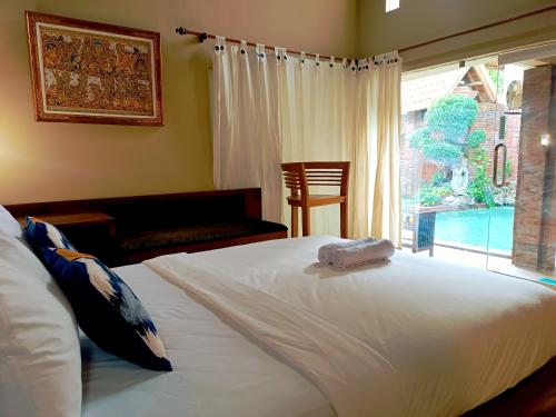 una camera da letto con un grande letto bianco e una finestra di Southern Bali Villa a Nusa Dua