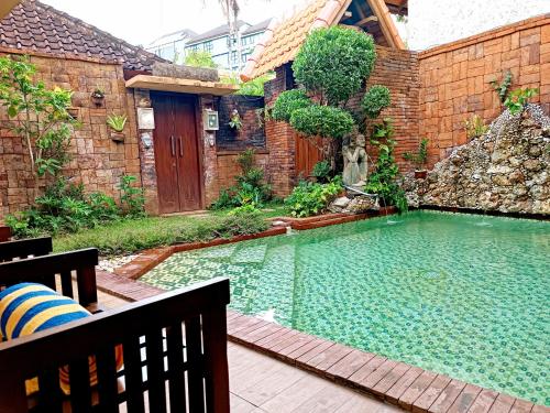 a large swimming pool in a yard with a bench at Southern Bali Villa in Nusa Dua