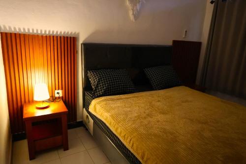 ein Schlafzimmer mit einem Bett und einer Lampe auf einem Tisch in der Unterkunft Pondok Dete Guesthouse in Sanur