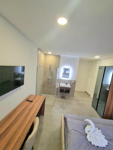 a bedroom with a bed and a desk and a shower at G&G Boardinghouse in Aalen