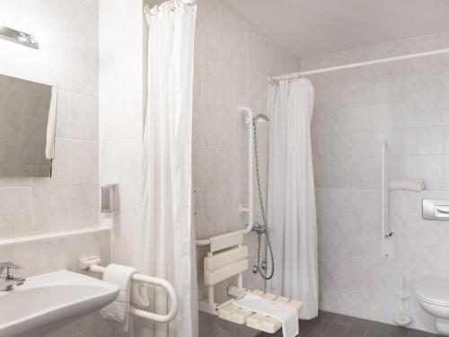 ein Bad mit einer Dusche, einem WC und einem Waschbecken in der Unterkunft Good Morning + Berlin City East in Berlin