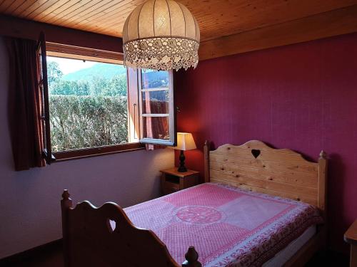 une chambre avec un lit aux murs violets et une fenêtre dans l'établissement Appartement calme près du lac avec jardin, terrasse, parking et WiFi - FR-1-624-45, à Samoëns