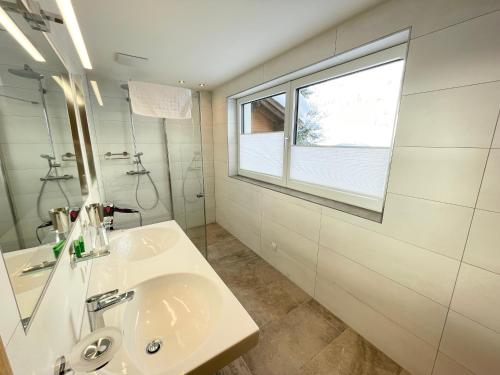 a white bathroom with a sink and a window at Apart 7 Stuben in Stuben am Arlberg