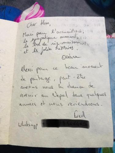 a handwritten letter with a pen on a sheet of paper at Hom's Homestay Retreat Sarangkot Pokhara in Pokhara