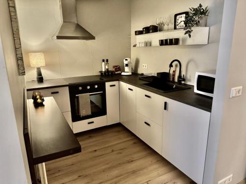 een keuken met witte kasten en een zwart aanrecht bij Akureyri Backpackers, Hafnarstraeti 100 - Apartment for 4 in Akureyri