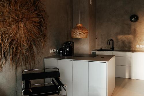 een keuken met witte kasten en een zwarte stoel bij Tulum Apartament - Luxury & Top Design - Bath - Spodek - Free Parking in Katowice