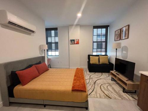 sypialnia z łóżkiem, telewizorem i kanapą w obiekcie Urban Studio: Downtown Hartford w mieście Hartford