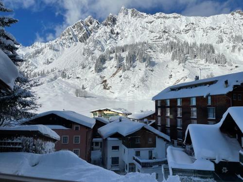 a snow covered mountain in front of a building at Apart 7 Stuben in Stuben am Arlberg