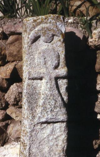 a stone cross on the side of a stone wall at CERA in Barcelona