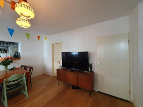 a living room with a television and a dining room table at Appartement met 2 slaapkamers en tuin in Amsterdam in Amsterdam