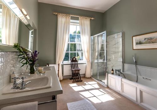 Luxury country mansion in West Cork في باندون: حمام مع حوض وحوض استحمام ودش