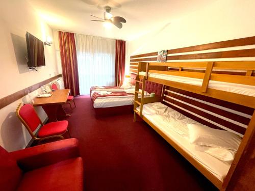 um quarto de hotel com 2 beliches e uma secretária em Cabana Sura Getilor Arinis em Voronet