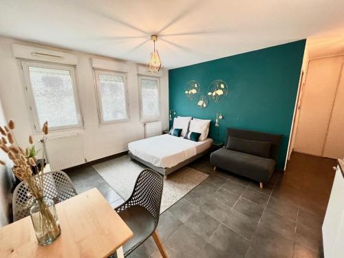 Cette chambre comprend un lit, un canapé et une table. dans l'établissement Agatha : ACCES FACILE GARE PARDIEU / EUREXPO / AEROPORT / GROUPAMA STADIUM, à Villeurbanne