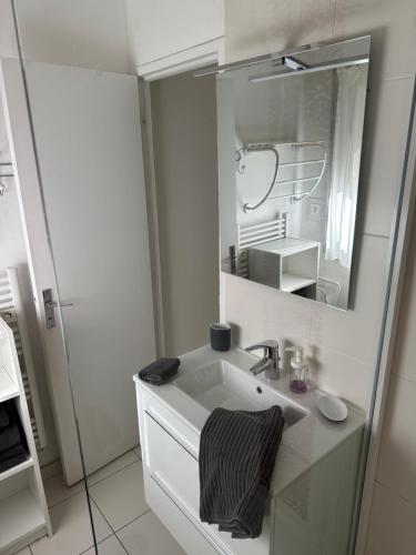 a white bathroom with a sink and a mirror at Appartement Design VIII - Port Rosmeur - Sublime vue Mer in Douarnenez
