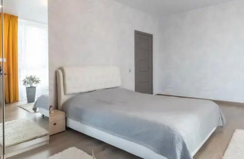 Un dormitorio blanco con una cama grande y una ventana en VIP apart 565, en Tiflis