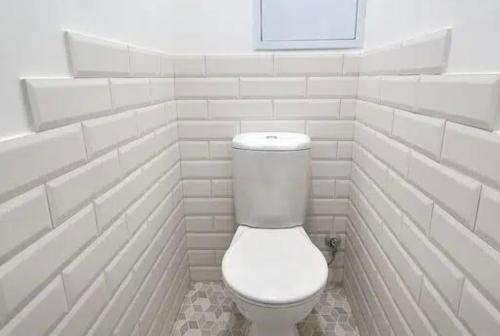 baño con azulejos blancos y aseo blanco en VIP apart 565, en Tiflis