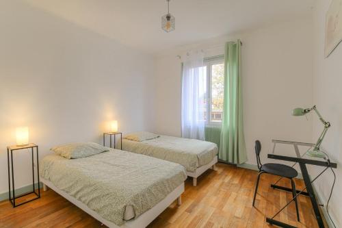 維尼西厄的住宿－Le Parilly - Ma Cabotte，一间卧室设有两张床和窗户。