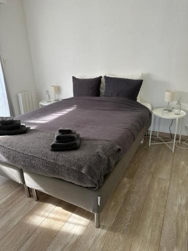 ドゥアルヌネにあるAppartement Design VIII - Port Rosmeur - Sublime vue Merのベッドルーム1室(大型ベッド1台、テーブル2台付)