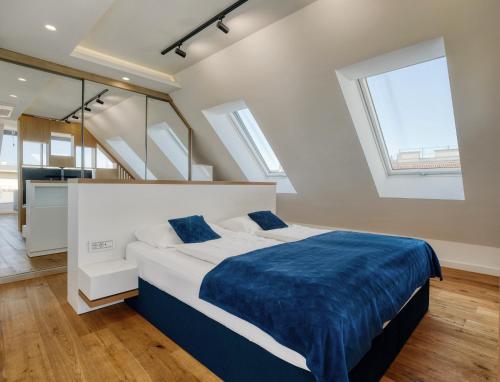 um quarto com uma cama com lençóis azuis e janelas em Nook Zehn Apartments & Loft by Irundo em Viena