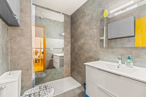uma casa de banho com um lavatório branco e um chuveiro em Sunflower Siroco em Santa Pola
