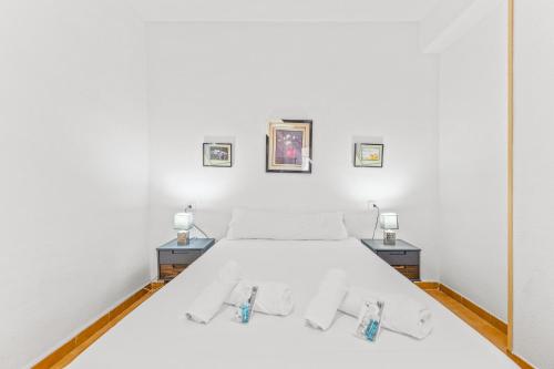 um quarto com uma cama branca e duas mesas de cabeceira em Sunflower Siroco em Santa Pola