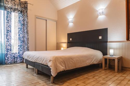 um quarto com uma cama grande e uma janela em Village de gîtes de Sainte-Lucie em Sainte-Lucie