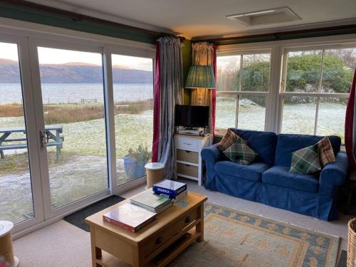 a living room with a blue couch and a table at Alltcreich in Craignure