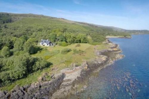 an aerial view of a house on a hill by the water at Alltcreich in Craignure