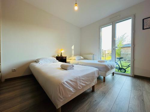 1 dormitorio con 2 camas y ventana grande en La maison de Rochefuret, en Ballan-Miré