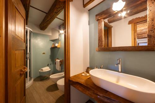 a bathroom with a white sink and a toilet at Chalet d'Aoste in Aosta