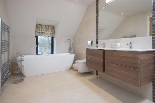 a bathroom with a tub and a toilet and a sink at Coledale Stables in Kelso