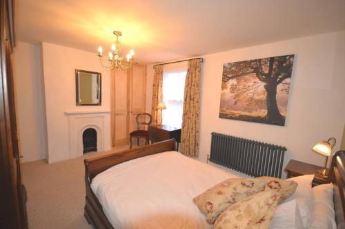 a bedroom with a bed and a fireplace and a window at Delightful Cottage in Sandwich - One Bedroom in Sandwich