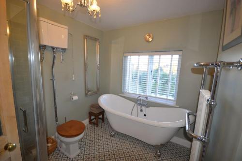 La salle de bains est pourvue d'une baignoire, de toilettes et d'un lavabo. dans l'établissement Delightful Cottage in Sandwich - One Bedroom, à Sandwich