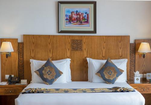a bedroom with a large bed with two pillows at Grand Mogador Sea View & Spa in Tangier