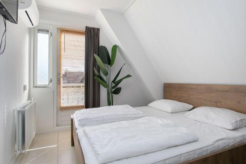 Wellness Landhuis Drenthe في Schoonloo: غرفة نوم بيضاء بها سرير ونافذة