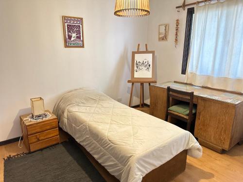 1 dormitorio con cama, escritorio y mesa en BlackBird apartamentos en San Carlos de Bariloche