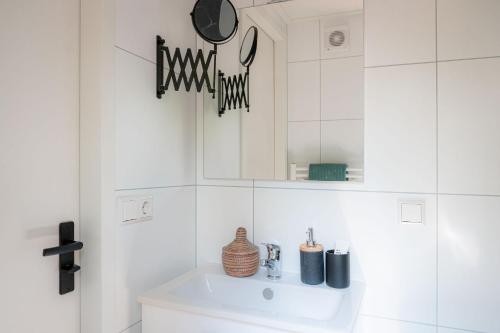 a white bathroom with a sink and a mirror at Lodge Steltloper Nunspeet Veluwe in Nunspeet