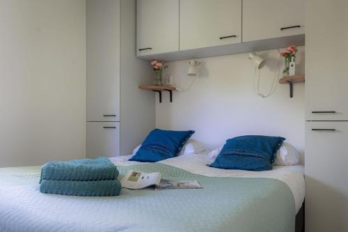 um quarto com 2 camas e almofadas azuis em Lodge Steltloper Nunspeet Veluwe em Nunspeet