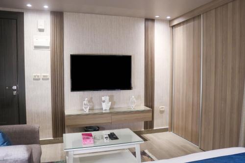 Una televisión o centro de entretenimiento en Red Carpet Hotel & Suites