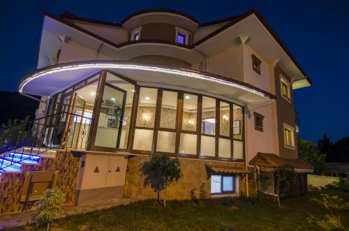a large house with a lot of windows at night at Funda Hotel in Göcek