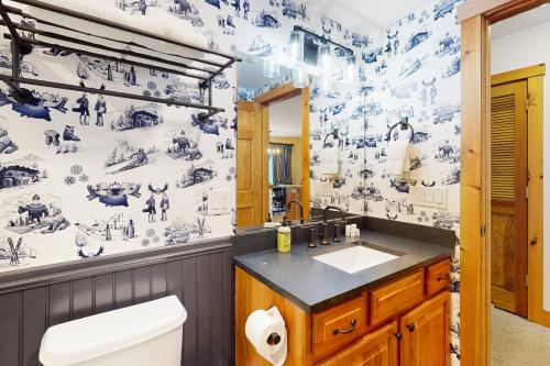 baño con papel pintado de color azul y blanco en Jay Peak Village Home 375 en Jay