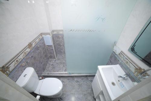 a bathroom with a toilet and a sink at Hotel Tinchlik Plaza in Urganch